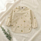 Lemon weaning apron on linen — Natural Nursery weaning apron lifestyle